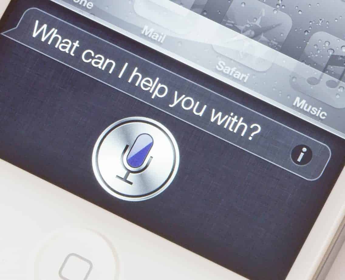 Chat bot history concept. A white Apple iPhone 4S showing the new Siri voice application. Siri is a voice recognition system which allows users to control the phone by using spoken words.